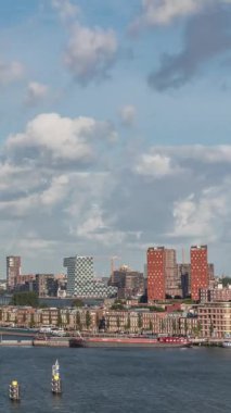 Arka planda Katendrecht ve Maas Nehri 'nin yer aldığı Maashaven' ın havadan görüntüsü. Sıcak sabah ışığıyla gökdelenlerin üzerinde dramatik bulutlu bir gökyüzü. Arkaplanda kargo portu