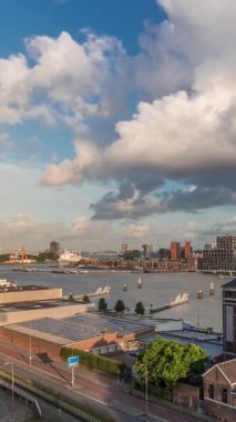 Arka planda Katendrecht ve Maas Nehri 'nin bulunduğu Maashaven üzerindeki hava zaman dilimi görüntüsü. Eski fabrika ofis ve etkinlik alanına dönüştü. Gökdelenlerin üzerinde dramatik bulutlu gökyüzü. Yollar boyunca trafik