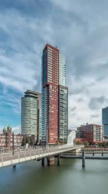 Hollanda, Rotterdam 'da bulunan ve yerel olarak Hoerenloper olarak bilinen Rijnhaven Köprüsü' nden Hiperlapse. Arka planda modern gökdelenleri ve bulutlu gökyüzü olan bir yaya ve bisiklet köprüsü