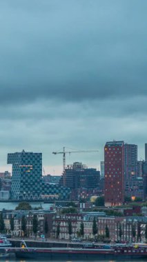 Rotterdam, Hollanda 'daki Katendrecht Yarımadası ve Maashaven Limanı' nın panoramik hava ve gece geçiş zamanı. Şehir silueti modern gökdelenler ve geleneksel Hollanda rıhtım evleri