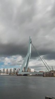 Hollanda, Rotterdam 'daki Maas Nehri' ni kapsayan Erasmus Köprüsü zaman atlaması. Hollanda 'nın en büyük kablo destekli basküle köprüsü gökdelenleri, tekneleri ve dramatik bulutlu arkaplanı