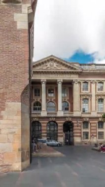 Rönesans zindanı ve Capitole arka tarafındaki klasik tuğla cephesi zaman atlaması, Fransa 'nın Toulouse belediyesi, Charles de Gaulle Meydanı' nda bulutlu bir gökyüzünün altında ağaçlarla çevrili.