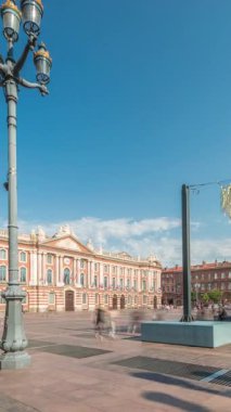 Capitole de Toulouse zaman çizelgesini gösteren panorama, Fransa 'nın Toulouse şehrinin tarihi belediye binasını ve belediye merkezini gösteriyor. Capitole Meydanı' nda mavi bulutlu gökyüzü altında birçok restoran bulunuyor.