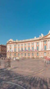 Capitole de Toulouse zaman çizelgesini gösteren panorama, Fransa 'nın Toulouse şehrinin tarihi belediye binası ve belediye kalbini, Capitole Meydanı' nda, çarpıcı mavi bulutlu gökyüzünün altında sergiliyor.