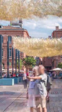 Fransa 'nın Toulouse şehrinde Capitole Meydanı' nda. İkonik kırmızı tuğlalı tarihi ön cephelerde açık hava kafeleri, beyaz şemsiyeler ve süslemeli ışıklandırmalar var. Canlı bir yaya istikameti.