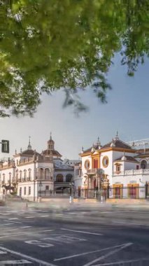 Plaza de Toros de la Real Maestranza de Caballeria de Sevilla zaman atlaması. İspanya 'nın Seville şehrinde boğa güreşi festivalleriyle tanınan tarihi boğa güreşi. Trafik ön cephesinin önünden geçiyor.