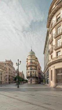 Avda boyunca yürüyen yayalar. De la Constitucion, Seville, İspanya 'nın Casco Antiguo bölgesindeki ana cadde. Edificio de la Adriatica ile zaman atlaması, tarihi binalar ve geçen tramvaylar