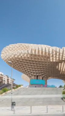 Encarnacion Meydanı 'ndaki Metropol Şemsiyesi zaman atlaması, panoramik yürüyüş yolu ve bir arkeoloji müzesi olan fütürist ahşap yapı. Mavi gökyüzü, merdivenler, trafik ve şehir manzarası Sevilla, İspanya