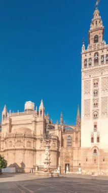 Seville Katedrali ve Giralda Kulesi 'nin Sevilla, İspanya' daki aşırı hızını gösteren panorama. Dünyanın en büyük gotik katedrali Virgen de los Reyes meydanında, mavi gökyüzünün altında.