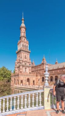 Panorama, Seville Timelapse 'de Plaza de Espana' yı gösteriyor. Maria Luisa Park 'ta Ibero-American Exposition için inşa edilmiş büyük bir mimari kompleks. Mavi gökyüzünün altında köprüler, kanallar ve klasik sokak lambaları