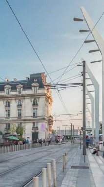 Fransa 'nın Aquitaine kentindeki ana demiryolu merkezi olan Bordeaux Saint Jean Tren İstasyonu, saatli büyük bir girişe sahiptir. Günbatımında tramvaylar geçer, tarihi cephede gölgeler hareket eder.