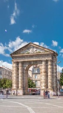 Fransa, Bordeaux 'da Place de la Victoire' da Porte dAquitaine kemeri ve dikilitaş. Tramvay hatları, kafeler ve mavi bulutlu gökyüzünün altında çevreleyen canlı Bordeaux 'nun tarihi simgesi.