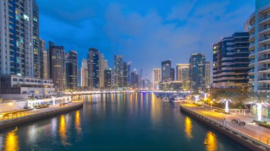 Dubai Marina rıhtımında, Dubai 'deki köprüden gece gündüz havadan görüntüsü olan kuleler ve yatlar Birleşik Arap Emirlikleri' ne geçiş zamanı. Dubai Marina, Dubai 'de bir şehirdir.