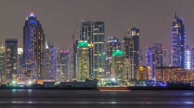 Dubai Marina silueti, Dubai, BAE 'deki Palm Jumeirah' dan görüldüğü gibi JBR 'den geceye geçiş zamanı panoraması. Dubai 'nin bu kısmında 50 kattan fazla gökdelen var.