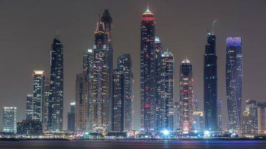 Dubai Marina ufuk çizgisi günden geceye geçiş zamanı panorama Palm Jumeirah, Dubai, BAE 'den görüldüğü gibi. Dubai 'nin bu kısmında 50 kattan fazla gökdelen var.