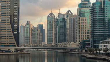 Dubai Marina Kanalı 'nın sabah manzarası, modern kuleleri ve yatlarıyla Dubai' deki köprüden yansıyan güneş doğumu saati, Birleşik Arap Emirlikleri.