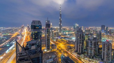 Dubai 'nin panoramik silueti günden geceye geçiş zamanı, Birleşik Arap Emirlikleri. Ünlü gökdelenler kule çatısı manzaralı. Güzel bulutlu gökyüzü. Renkli seyahat ve iş geçmişi