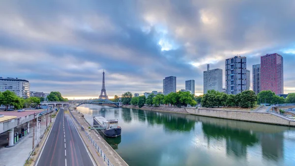 Eyfel Kulesi Seine Nehri 'nde ve Fransa' nın Paris şehrinde teknelerle renkli gündoğumu zamanı. Grenelle Köprüsü 'nden hava görüntüsü. Modern binalar ve yol trafiği. Dramatik bulutlar