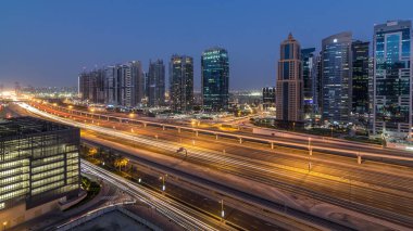 Jumeirah göl kulelerinin hava panoramik görüntüsü gökdelenler günden geceye geçiş zamanı Sheikh zayed yolu ve metro hattı trafiği.