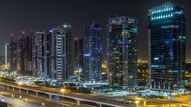 Jumeirah göl kuleleri gökdelenleri olan gökdelenlerin hava görüntüsü tüm gece boyunca Sheikh zayed yolunda trafik ve ışıklar kapanıyor. Dubai marinasından çatı manzarası