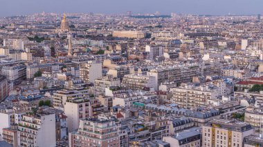 Paris 'teki evlerin çatılarının üstündeki hava panoraması gece gündüz geçiş zamanı. Günbatımından sonra aydınlanan kubbe ve diğer manzaralarla akşam manzarası