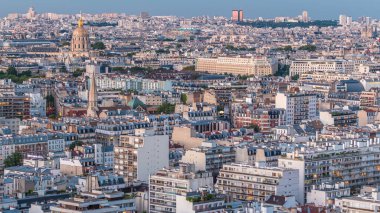 Paris 'teki evlerin çatılarının üstündeki hava panoraması gece gündüz geçiş zamanı. Günbatımından sonra aydınlanan gece manzarası, kiliseler ve diğer manzaralar.