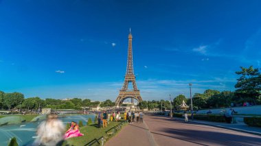 Paris, Fransa 'daki Jardins du Trocadero' daki fıskiyeyle Eyfel Kulesi 'nin zaman atlaması manzarası. Uzun gölgeler. Etrafta dolaşan insanlar. Eyfel Kulesi, Paris 'in en ikonik simgelerinden biridir.