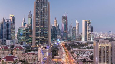 Şeyh Zayed Yolu 'nun Skyline manzarası ve Dubai, BAE' deki gece gündüz geçiş zamanı. Finansal merkezdeki aydınlık gökdelenler şehir merkezinin yukarısından gökyüzü manzarası