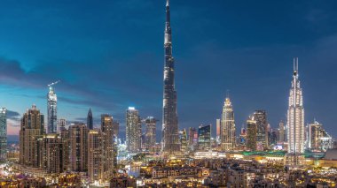 Dubai Şehir Merkezi 'nin ufuk çizgisi gece gündüz Burj Halife ve diğer panoramik manzaralı Dubai, Birleşik Arap Emirlikleri. Geleneksel ve modern binalar. Çember yollarda ve çeşmelerde trafik