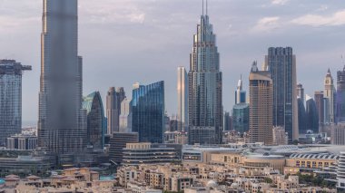 Dubai Şehir Merkezi 'nin ufuk çizgisi gün batımından gece saatlerine kadar Dubai, Birleşik Arap Emirlikleri' nin tepesinden panoramik manzaralı kulelerle dolu. Güneş gökdelenden yansıyor. Çember yollarda ve çeşmelerde trafik