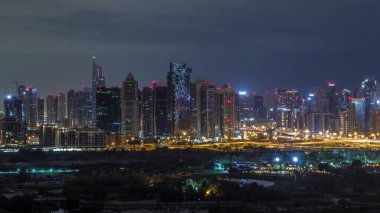 Jumeirah göl kuleleri ve Dubai marina yanıp sönen ışıklar, Dubai, Birleşik Arap Emirlikleri ile tüm gece zaman aşımı sırasında gökdelenler ve golf sahası aydınlatılmış. Yeşiller bölgesinden havadan görünüm