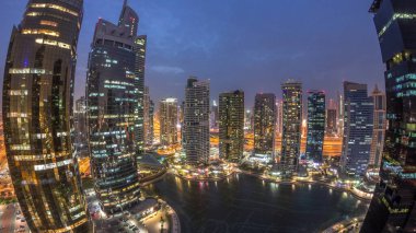 Jumeirah göl kuleleri konut ve ofis binaları Dubai'de gece geçiş timelapse ilçe gün. Modern gökdelenler ile yukarıdan havadan panoramik görünüm