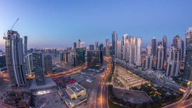 Dubai İş Sahası Panorama 'sı gece gündüz geçiş zamanı. Gökdelenleri ve hareket eden uzun gölgeleri olan gökdelenler. Gün doğarken trafik vardı..