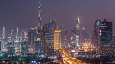 Gün batımından sonra Dubai silueti güzel şehir merkezi ışıkları ve Sheikh Zayed gece gündüz yol trafiği. Elizabeth bölgesinden aydınlık kuleler ve gökdelenlerin hava manzarası. Birleşik Arap Emirlikleri