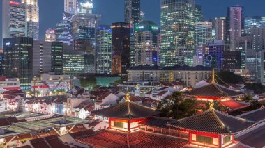 Buddha Diş Kalıntısı Tapınağı Singapur Çin Mahallesi 'nde gece gündüz canlanıyor. Arka planda şehrin silüeti var. Tapınak gökdelenler ve kulelerle aydınlık