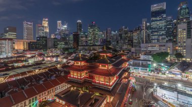 Buddha Diş Kalıntısı Tapınağı Singapur Çin Mahallesi 'nde gece gündüz canlanıyor. Arka planda şehrin silüeti var. Tapınak gökdelenler ve kulelerle aydınlık