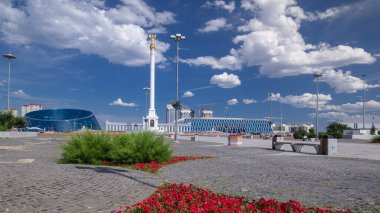 Yıldız heykeli Kazak Eli 'ın kuş Samruk ve Bağımsızlık Sarayı' nın zaman atlaması ve kırmızı çiçek tarhı ön planda. Nur-Sultan şehri, Kazakistan