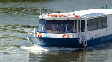 Astana, Kazakistan. Astana 'da Ishim nehrinde hareketli bir eğlence teknesi var. Yazın mavi gökyüzü ve bulutlarla