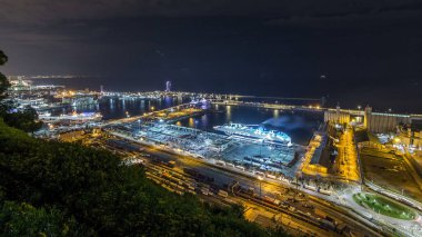 Port Vell timelapse, Barcelona, Katalonya, İspanya ile Montjuic gece manzarası. Gemi ve terminal ile Hill Hava üstten görünüm