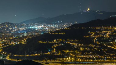 Barcelona ve Badalona Skylines 'ın Gece Zamanlaması. İberik Puig Castellar Köyü 'nden Havadan Bakış Alanı, Evlerin Çatıları, Ufukta Tibidabo, Yıldızlı Gece Gökyüzü Altında Aydınlandı