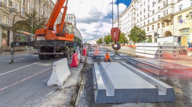 Vinç yol inşaat site timelapse hyperlapse, beton plaka yükleme. Kavganın ve üniforma ile sanayi işçileri. Sokak şehir tramvay yeniden inşası izler
