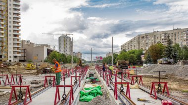 Kurulum aşamasındaki tramvay rayları ve zaman dilimindeki beton plakalara entegrasyon. Tramvay raylarının yeniden inşası. Bulutlu gökyüzü