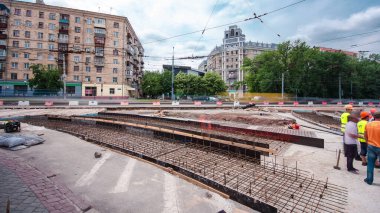 Tramvay rayları onarımı ve bakım zamanı olan bir yol inşaatı. Beton kavşağın orta kısmında işe yarar. Beton taban için metal ızgara