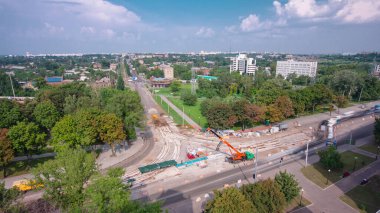 Tramvay rayları onarılan ve panoramik bakım yapan yol inşaatı. Kavşağın ortasına vinç üstüne beton plakalar ve bloklar yerleştirip boşaltıyorlar. Değiştirme