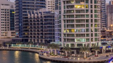 Geçen tekneler ve avuç içi gün gece ile promenade ile lüks Dubai Yat Limanı kanal timelapse geçiş, yukarıdan bakışta akşam güneş battıktan sonra Top. Dubai, Birleşik Arap Emirlikleri