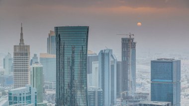 Günbatımında gökdelenler başkent Katar 'ın ticaret merkezi Doha' nın ufuk çizgisinde. Sisli havada hava manzarası. Bulutlu turuncu gökyüzü