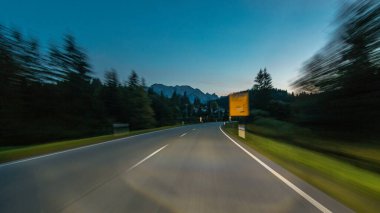 Avusturya, bir güzel sonbahar günü timelapse hyperlapse drivelapse Alpler'de asfalt yolda sürücü. Orman ve dağlar akşam