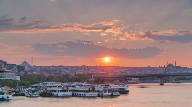 İstanbul 'un ufuk çizgisi İstanbul' da, günbatımında Boğaziçi ve Altın Boynuz 'daki tekne istasyonu yakınlarında çok sayıda yolcu feribotu bulunuyor. Arka planda cami ve köprü, bahar akşamında suyun yansımasıyla