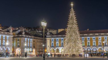 Lizbon 'daki ticaret meydanı, Noel' in aşırı hızıyla aydınlandı. Yükselen bir ağaç ve geceleri kutlayan kalabalıkla. Bir tepenin üzerindeki şenlikli atmosfer dekorasyonları ve tarihi mimarinin zamanı.