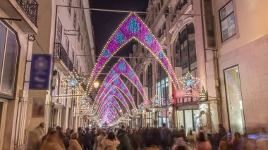 Lizbon şehir merkezindeki Chiado Carmo sokağındaki Noel ışıkları ve dekorasyonları gece aşırı hızlandı. İnsanlar aydınlanmış kemerlerin altında yürürler. Portekiz 'de festival dekorlu tatil atmosferi